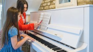 Teacher and child practicing piano